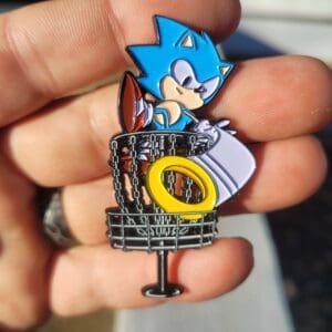 A person holding up a sonic the hedgehog pin.