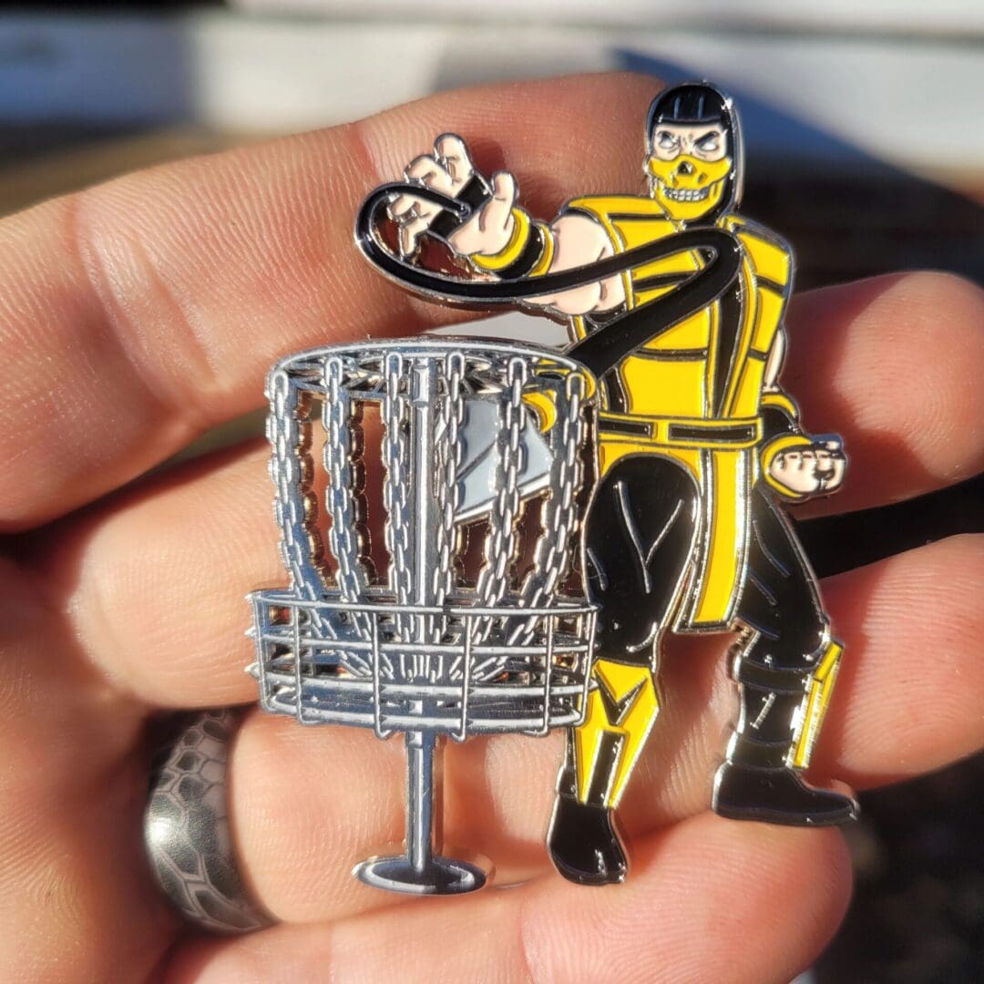 A man holding onto a metal pin with a yellow and black figure