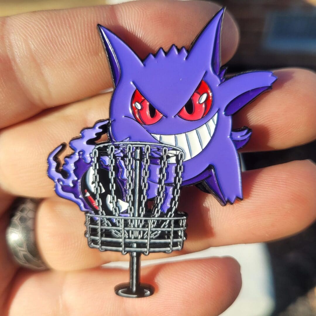 A person holding onto a pin with a purple monster