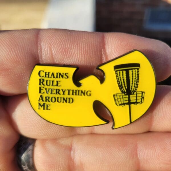 A yellow pin with the words chains rule everything around me.