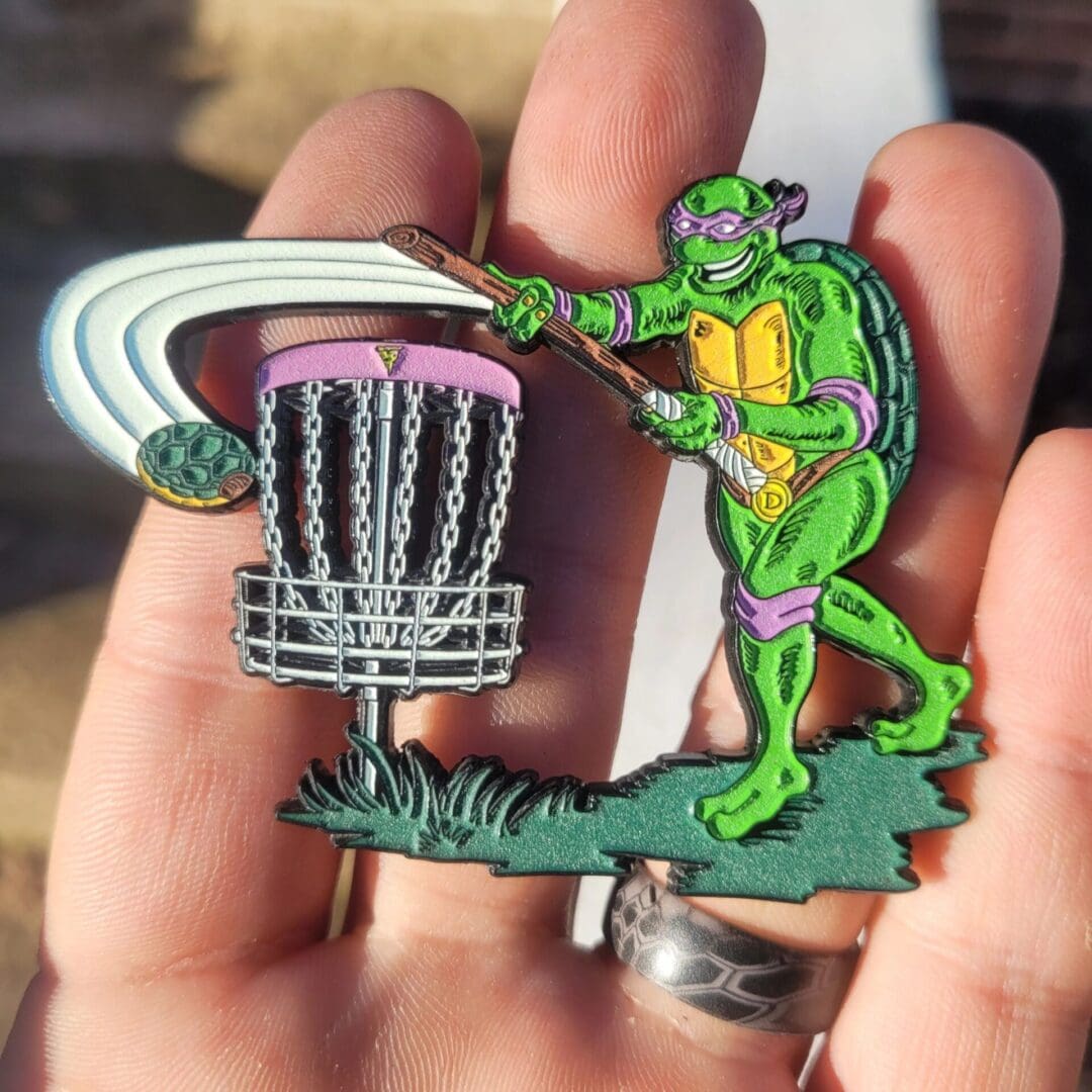 A person holding a frisbee and a pin