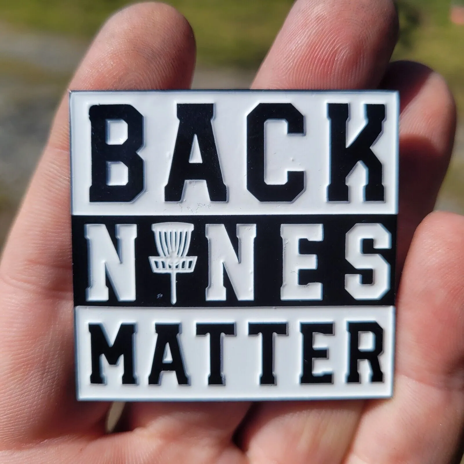 A person holding onto a back nine matter pin