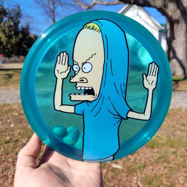 A hand holding a frisbee with an image of beavis.