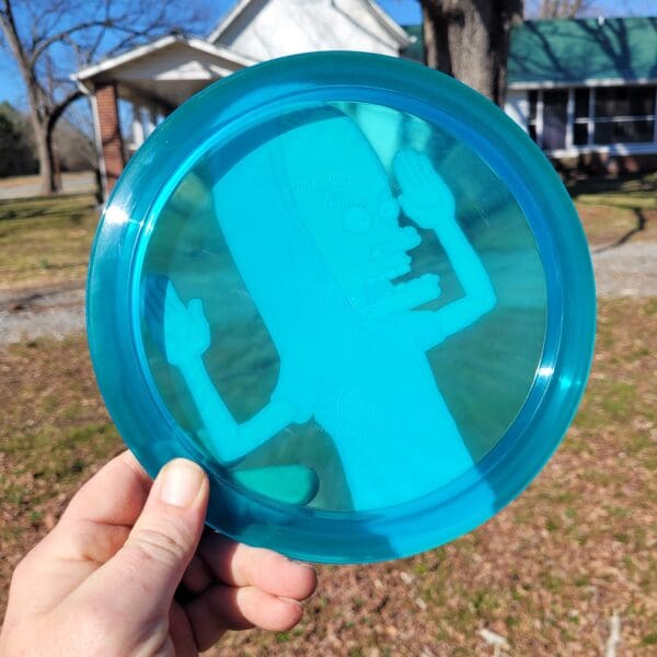 A person holding a frisbee in front of a house.