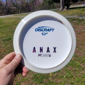 A person holding an anax frisbee in their hand.